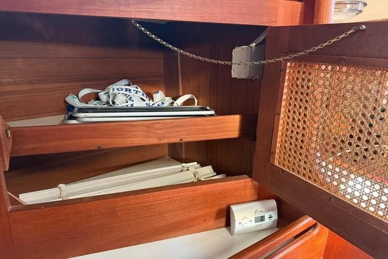 Slide: The Image of Wooden cabinet interior on a 1986 Tartan 37' sailboat, featuring shelves and a smoke detector. - 27