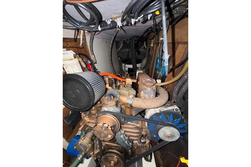 Slide: The Image of Engine compartment of a 1986 Tartan 37' sailboat, showing mechanical components and wiring. - 32