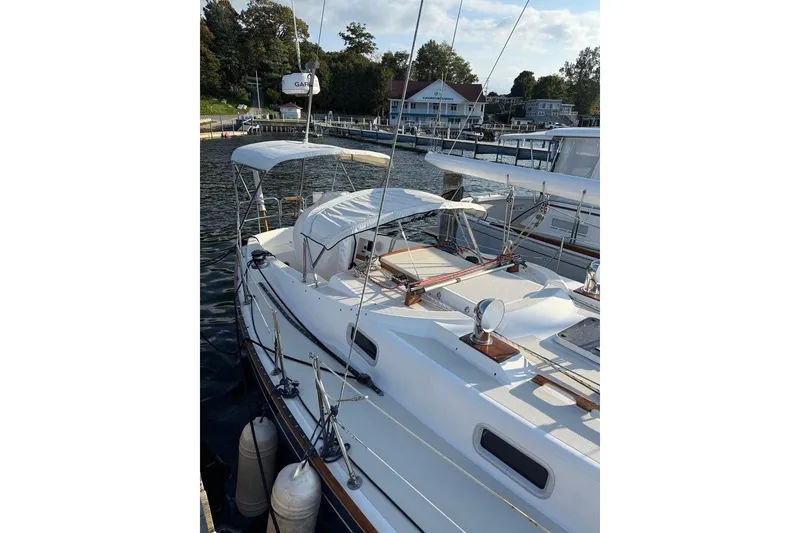 Slide: The Image of 1986 Tartan 37' sailboat docked at a marina, featuring a white canopy and sleek design. - 5