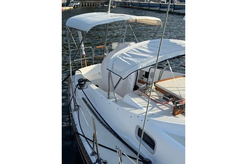 Slide: The Image of 1986 Tartan 37' sailboat with white canopy, docked on calm water. - 6