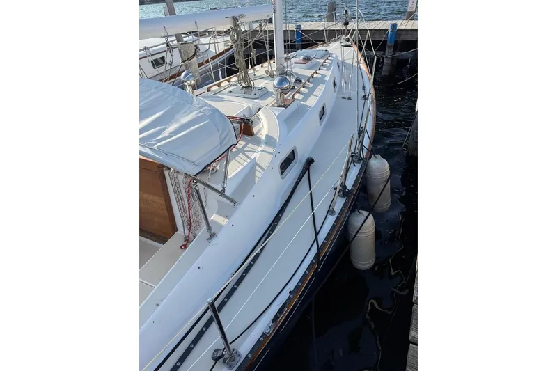 Slide: The Image of 1986 Tartan 37' sailboat docked, featuring a sleek white deck and rigging. - 7