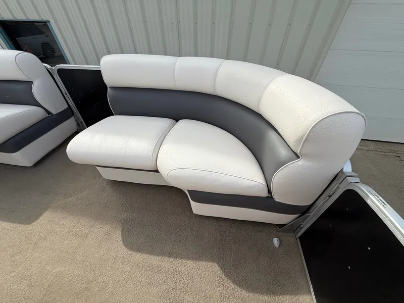 Slide: The Image of Premier 180 SunSation 2012 boat seating, white and gray upholstery, outdoor setting. - 10