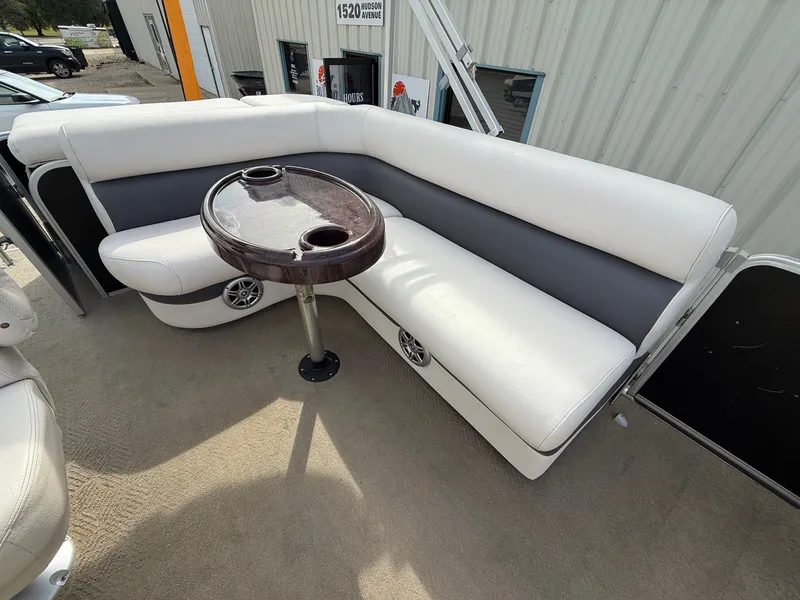 Slide: The Image of 2012 Premier 180 SunSation boat interior with white seating and a small round table. - 11