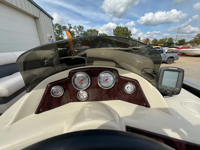 Slide: The Image of Dashboard of a 2012 Premier 180 SunSation boat with gauges and a Humminbird device. - 13