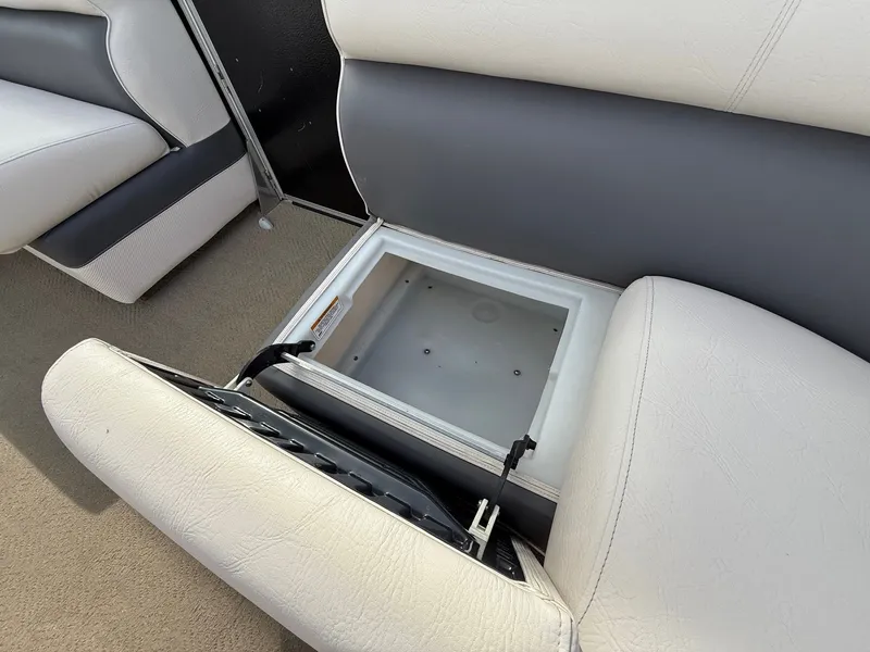 Slide: The Image of 2012 Premier 180 SunSation boat seat storage compartment open, revealing interior space. - 17