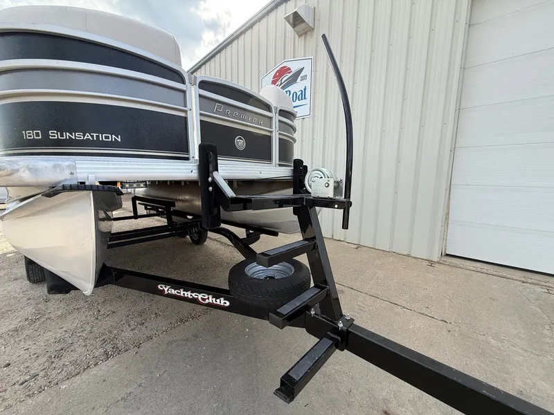 Slide: The Image of 2012 Premier 180 SunSation pontoon boat on Yacht Club trailer, parked outside a building. - 22