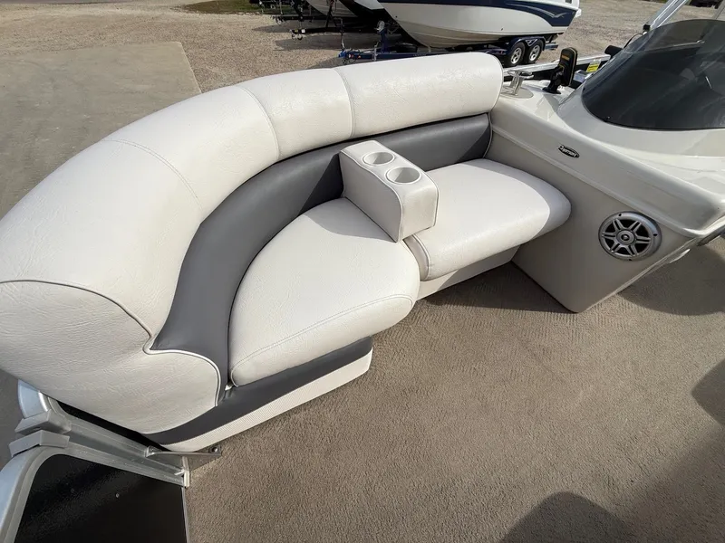 Slide: The Image of Premier 180 SunSation 2012 boat interior with white and gray seating, cup holders, and speaker. - 9