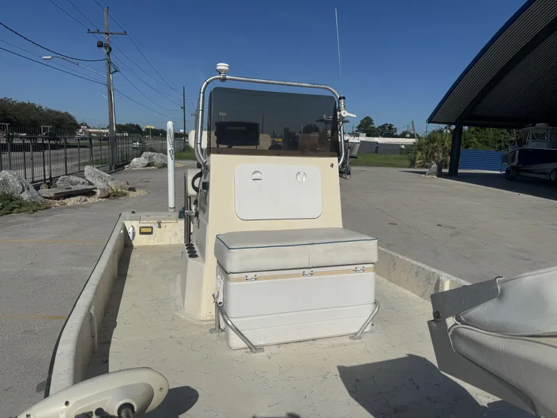 Slide: The Image of 2005 Flats Cat 21 boat interior with seating and console, parked outdoors. - 11