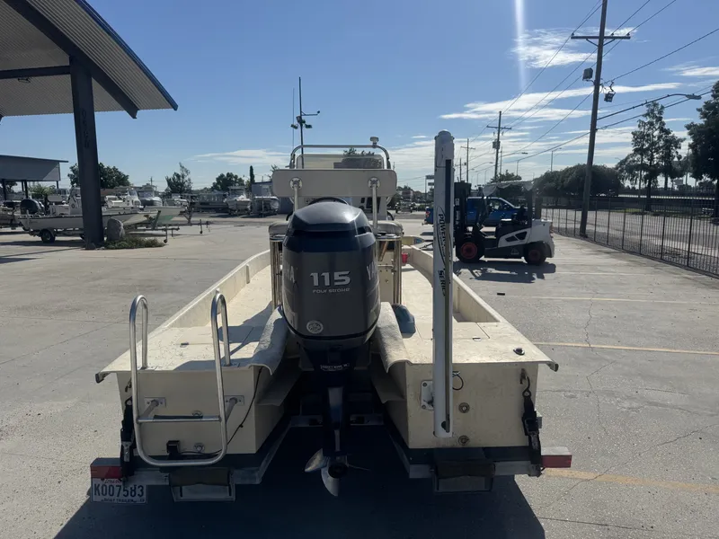 Slide: The Image of 2005 Flats Cat 21 boat with Yamaha 115 outboard motor in a parking lot. - 7