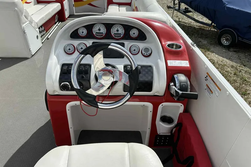 Slide: The Image of Steering console of a 2017 PlayCraft 2700 Extreme boat with red and white accents. - 12