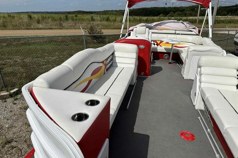 Slide: The Image of 2017 PlayCraft 2700 Extreme boat interior with white and red seating, cup holders, and open deck. - 14