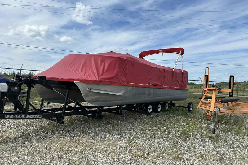 Slide: The Image of 2017 PlayCraft 2700 Extreme pontoon boat with red cover on trailer. - 17