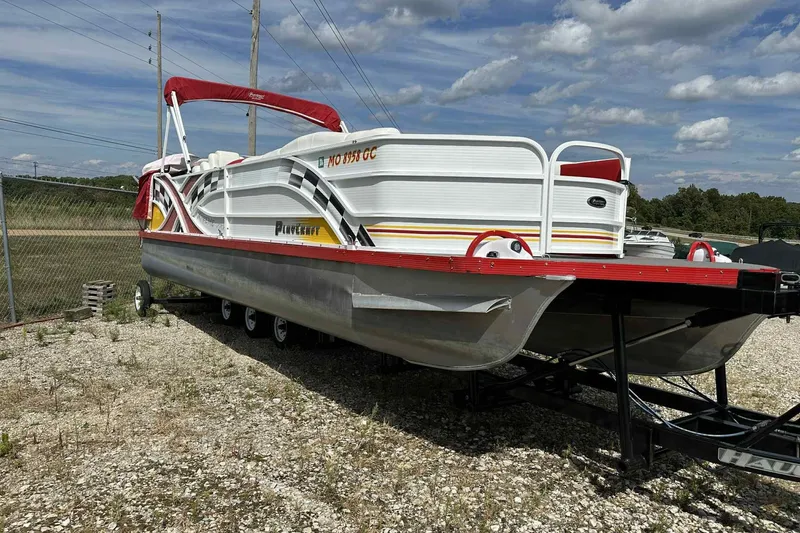 Slide: The Image of 2017 PlayCraft 2700 Extreme pontoon boat on trailer, red and white design, outdoor setting. - 18