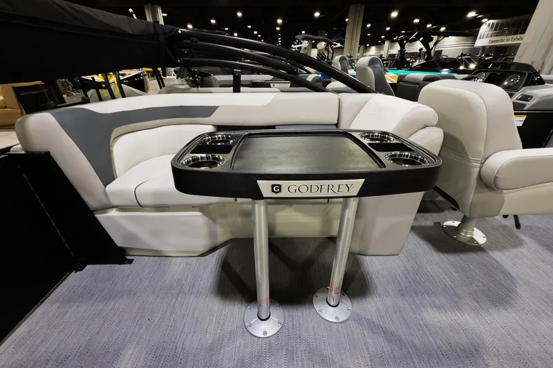 Slide: The Image of 2026 Godfrey Sweetwater 22' Tritoon interior with split bench and table setup. - 10