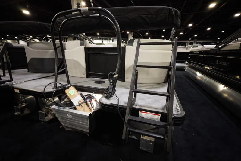 Slide: The Image of 2026 Godfrey Sweetwater 22' Tritoon with split bench, ladder, and storage compartment. - 16