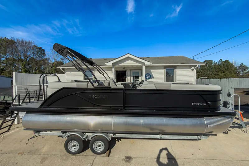 Slide: The Image of 2026 Godfrey Sweetwater 22' Split Bench Tritoon on trailer, parked in driveway. - 19
