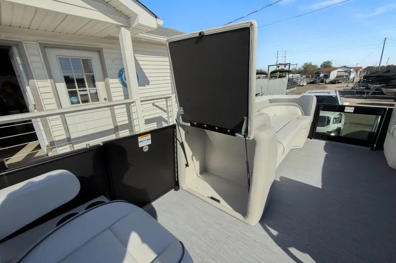 Slide: The Image of 2026 Godfrey Sweetwater 22' Tritoon interior with open storage compartment and seating. - 56