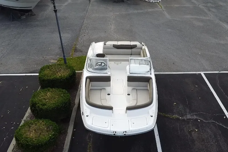 Slide: The Image of 2015 Bayliner 215 boat parked in a lot, aerial view. - 1