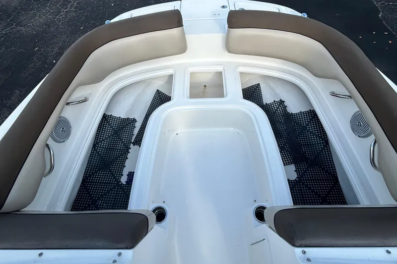 Slide: The Image of 2015 Bayliner 215 boat interior with cushioned seating and storage compartments. - 11