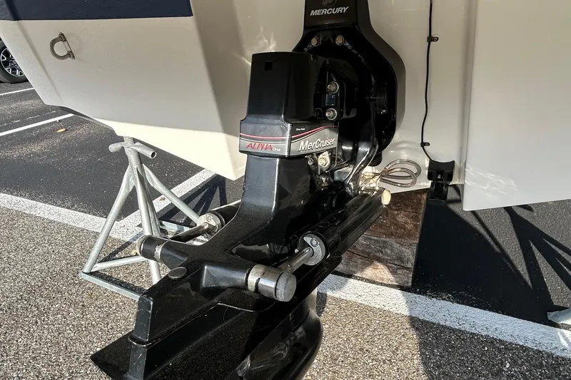 Slide: The Image of 2015 Bayliner 215 boat with MerCruiser Alpha One outdrive in a parking lot. - 15