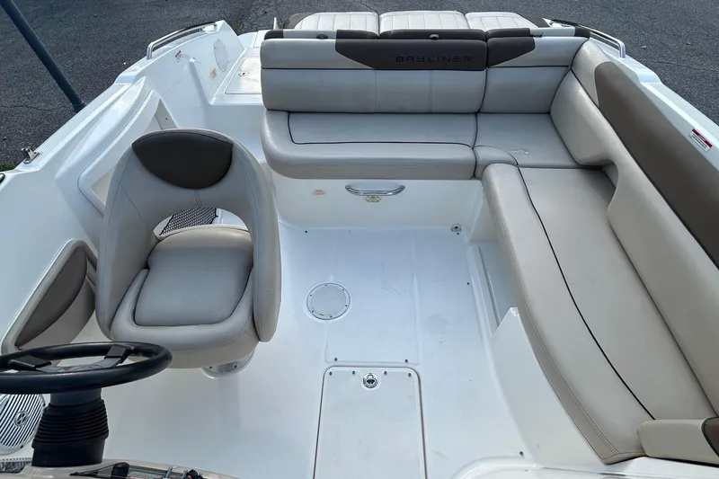 Slide: The Image of 2015 Bayliner 215 boat interior with seating and steering wheel. - 6
