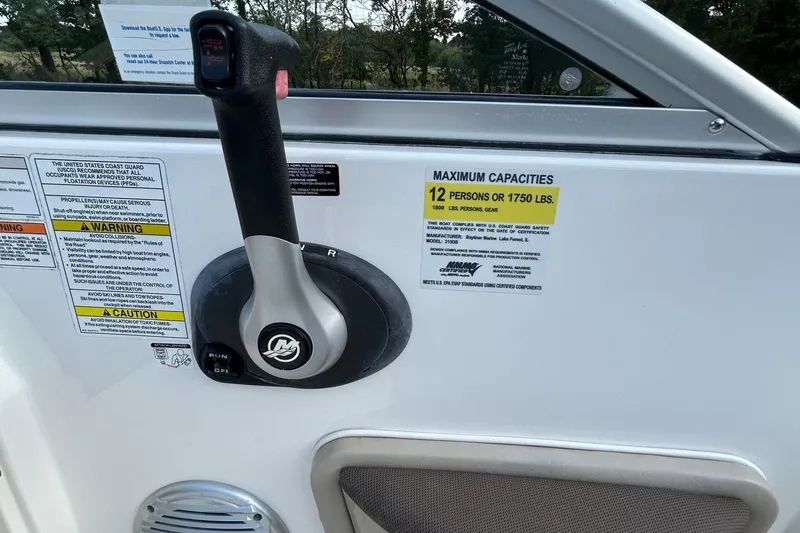 Slide: The Image of 2015 Bayliner 215 boat control panel with capacity warning label. - 8
