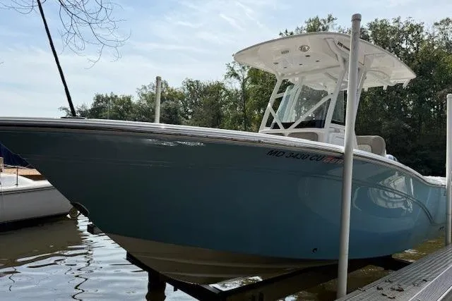 Slide: The Image of 2024 Sea Fox 228 Commander boat in light blue, displayed on stands outdoors. - 1