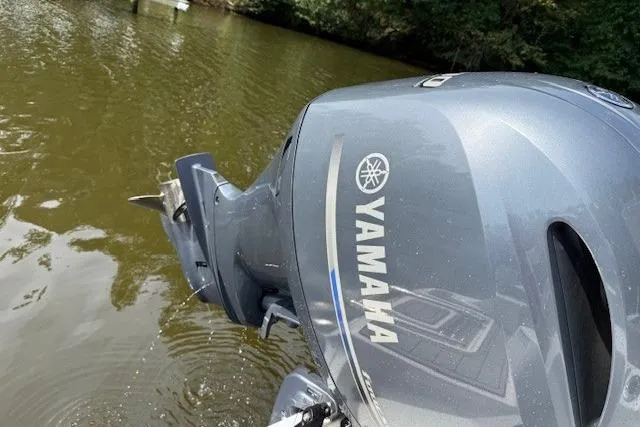 Slide: The Image of 2024 Sea Fox 228 Commander boat docked by a scenic riverside. - 5