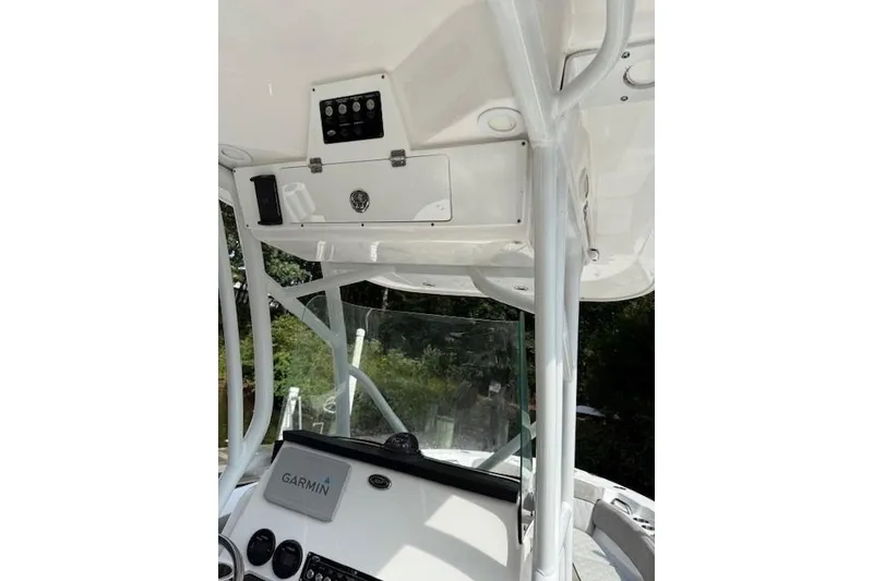 Slide: The Image of 2024 Sea Fox 228 Commander boat docked on a serene lake with lush trees. - 7