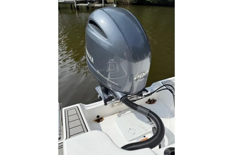 Slide: The Image of 2024 Sea Fox 228 Commander boat interior with seating and console, docked by a serene lake. - 9