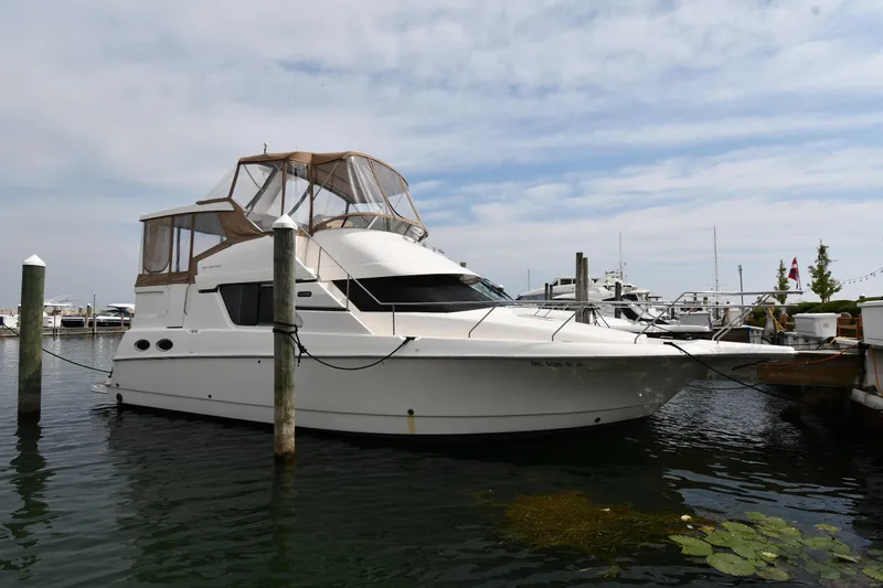 The Image of 2000 Silverton 392 Motor Yacht docked at marina under cloudy sky. - 1