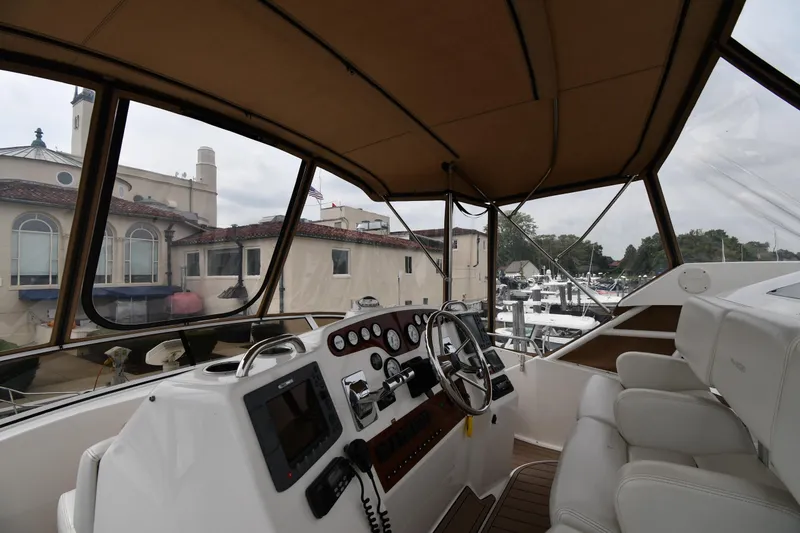 Slide: The Image of Interior view of 2000 Silverton 392 Motor Yacht helm with marina backdrop. - 15