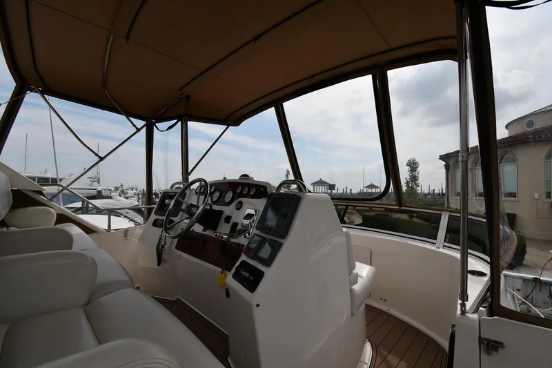 Slide: The Image of Interior view of a 2000 Silverton 392 Motor Yacht helm with steering wheel and controls. - 16