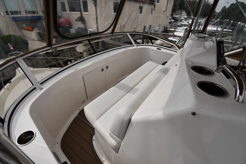 Slide: The Image of 2000 Silverton 392 Motor Yacht interior with seating and helm, docked at marina. - 23