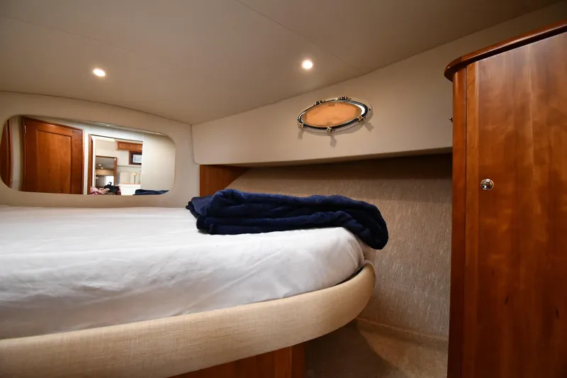 Slide: The Image of Cozy bedroom interior of 2000 Silverton 392 Motor Yacht with wooden cabinetry and soft lighting. - 29