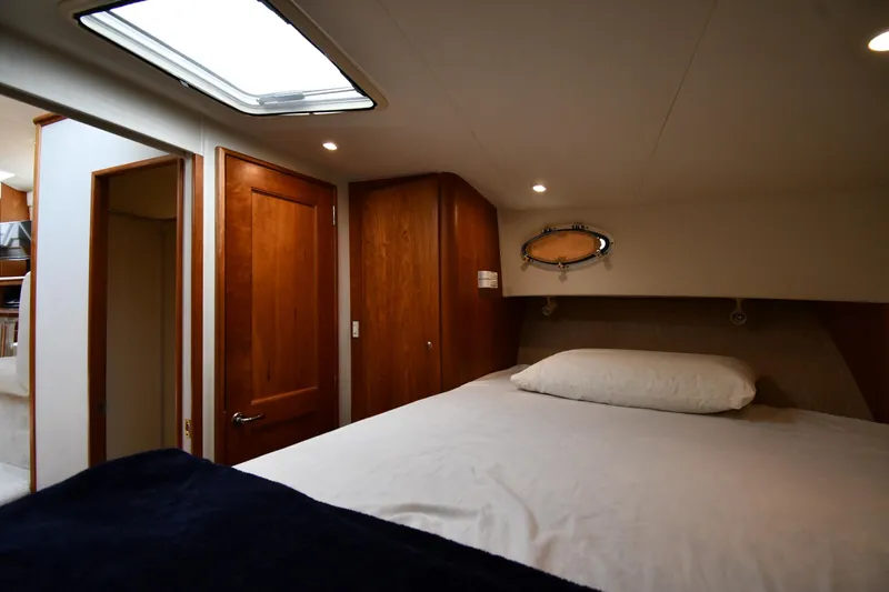 Slide: The Image of Interior of 2000 Silverton 392 Motor Yacht bedroom with wooden doors and skylight. - 31