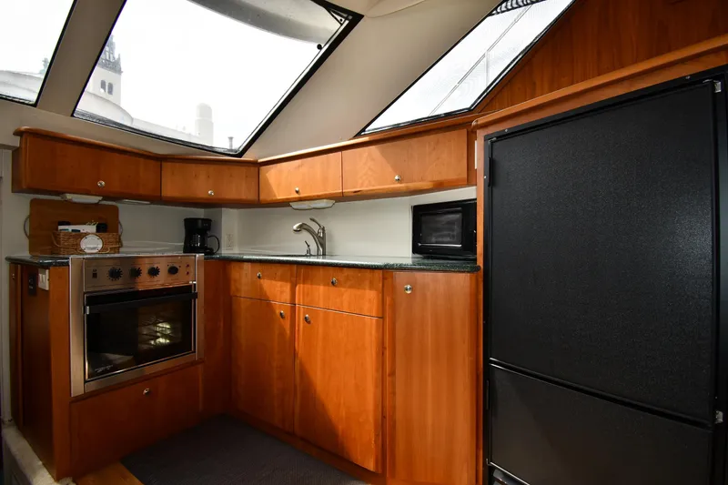 Slide: The Image of Luxurious kitchen interior of 2000 Silverton 392 Motor Yacht with wood cabinetry and modern appliances. - 40