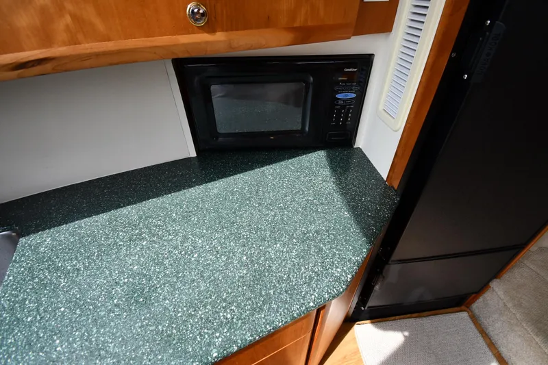 Slide: The Image of 2000 Silverton 392 Motor Yacht kitchen with green countertop and built-in microwave. - 42