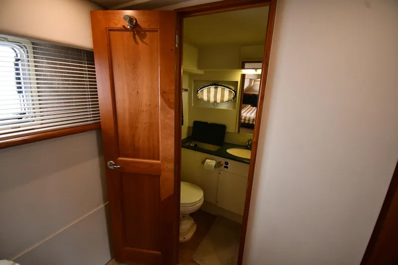 Slide: The Image of Interior of 2000 Silverton 392 Motor Yacht bathroom with wooden door and window blinds. - 51