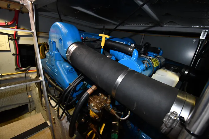 Slide: The Image of Engine room of a 2000 Silverton 392 Motor Yacht, featuring blue machinery and hoses. - 56