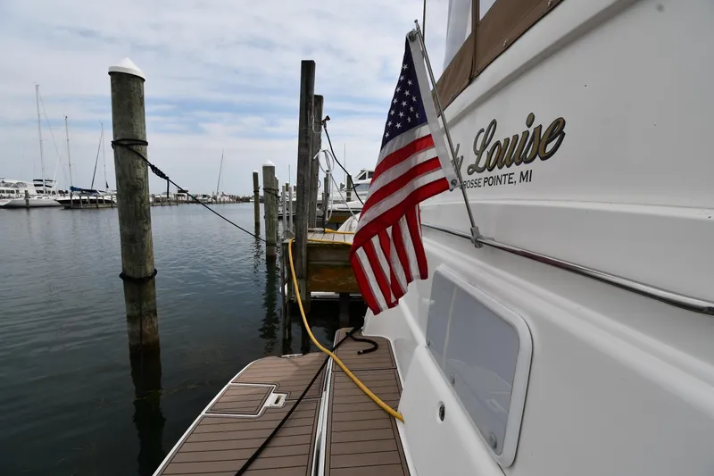 Slide: The Image of 2000 Silverton 392 Motor Yacht docked with American flag, marina view. - 8