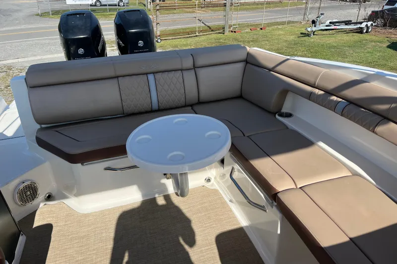 Slide: The Image of 2017 Sea Ray SDX 290 Outboard boat interior with beige seating and round table. - 11