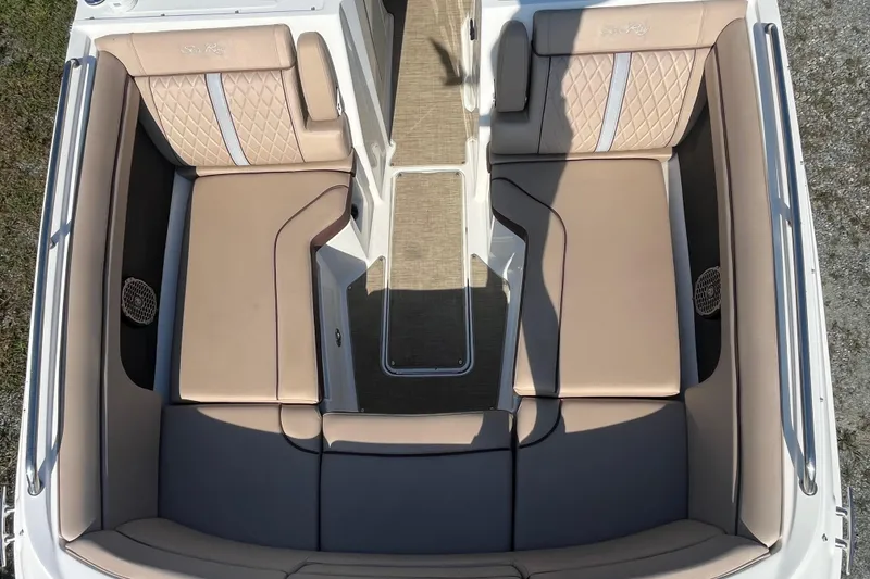 Slide: The Image of 2017 Sea Ray SDX 290 Outboard boat interior with beige cushioned seating and carpeted flooring. - 22