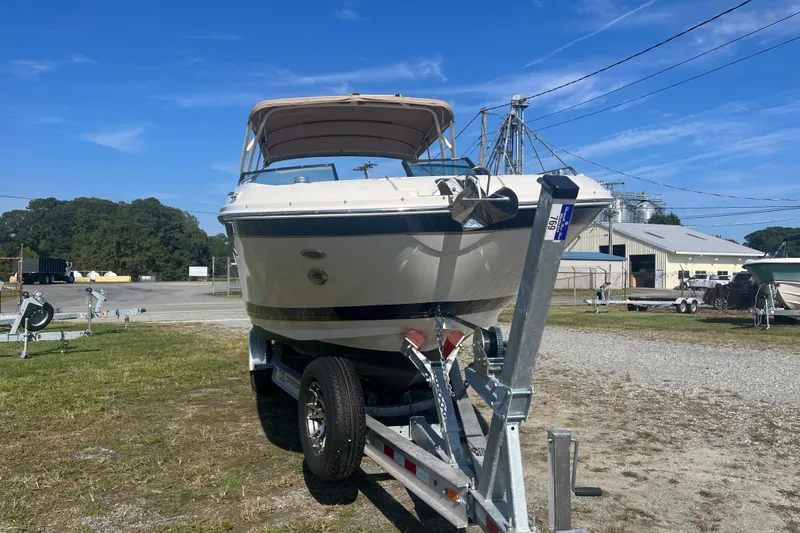 Slide: The Image of 2017 Sea Ray SDX 290 Outboard boat on trailer, parked outdoors under clear blue sky. - 25