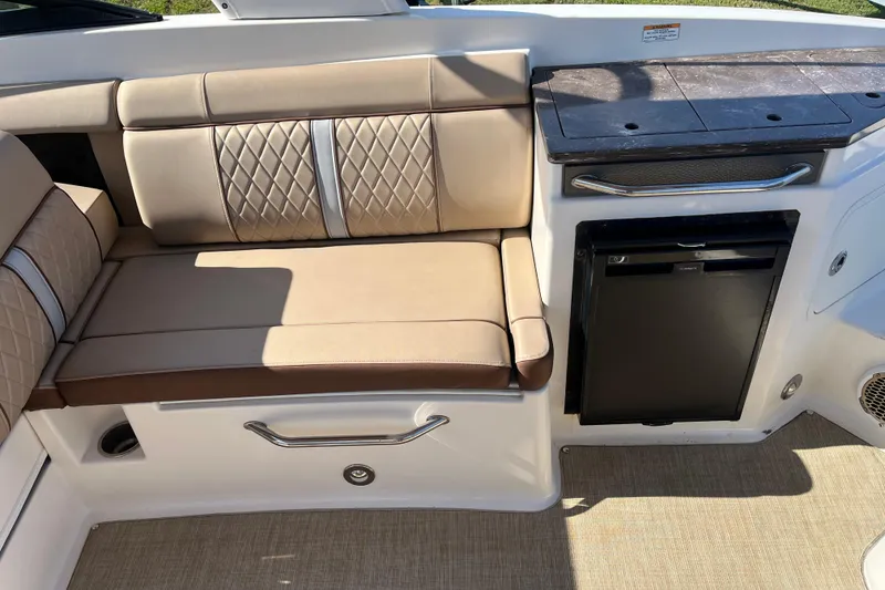 Slide: The Image of 2017 Sea Ray SDX 290 Outboard interior with beige seating and compact kitchenette. - 3