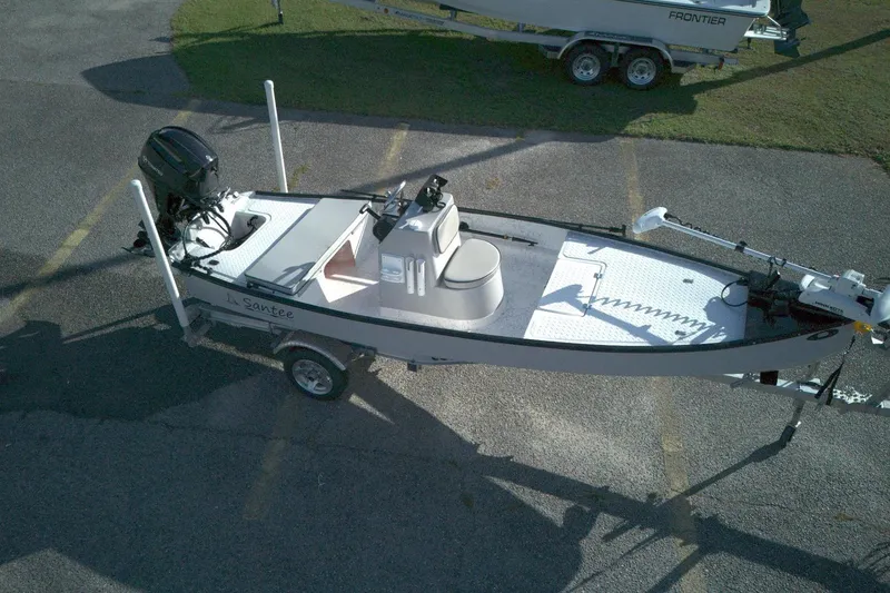 Slide: The Image of 2023 Santee 16CC boat on trailer, featuring outboard motor and spacious deck. - 1