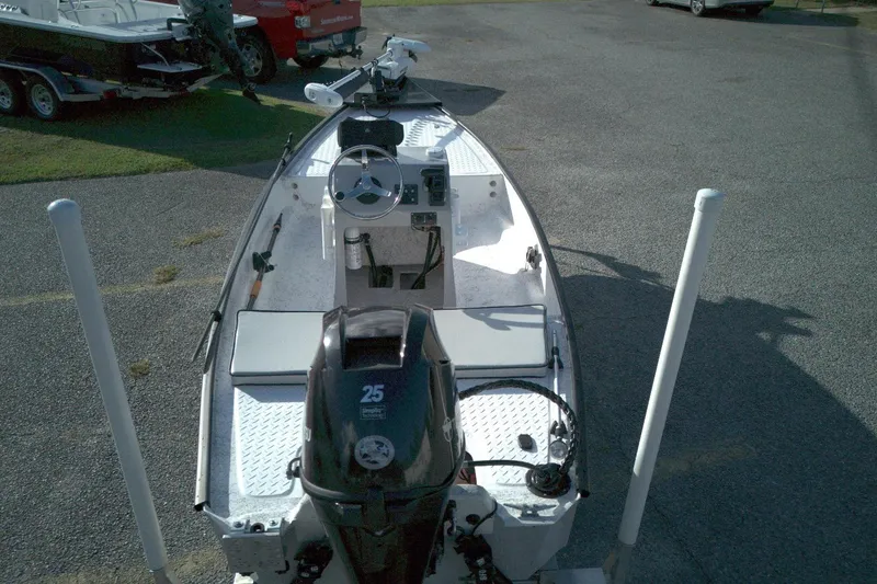 Slide: The Image of 2023 Santee 16CC boat with 25HP motor, parked on asphalt. - 2