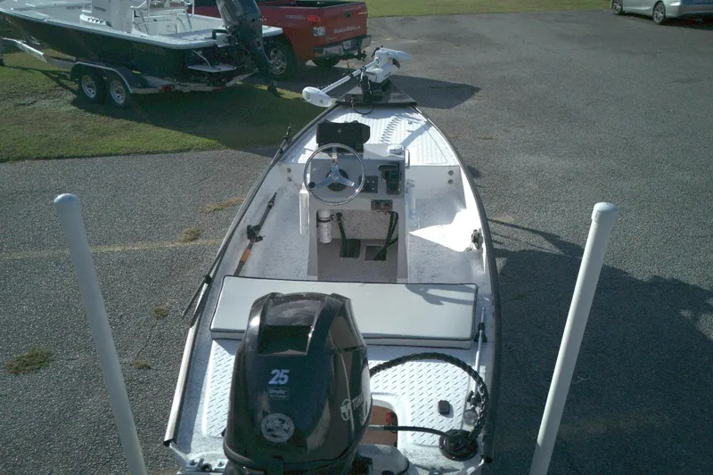 Slide: The Image of 2023 Santee 16CC boat with motor, parked on asphalt near other boats. - 5