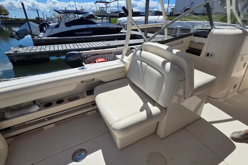 Slide: The Image of 2016 Grady-White Freedom 275 boat interior with seating, docked at marina. - 10