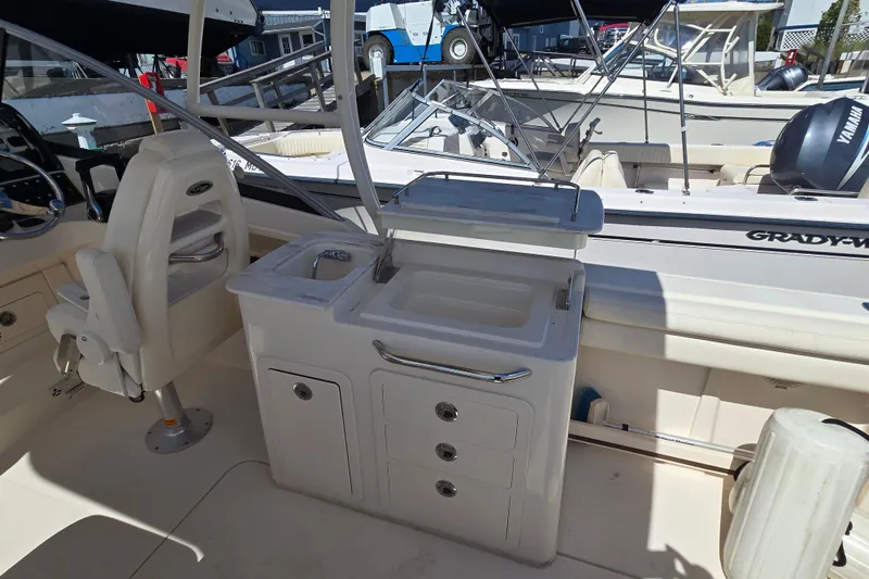 Slide: The Image of 2016 Grady-White Freedom 275 boat interior with sink and seating area. - 12